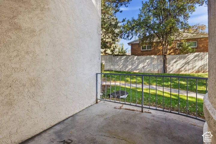 Stucco exterior with concrete patio and metal railing