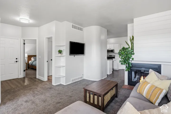 Built-in fireplace with a shiplap surround, integrated shelving, and wood-finish flooring