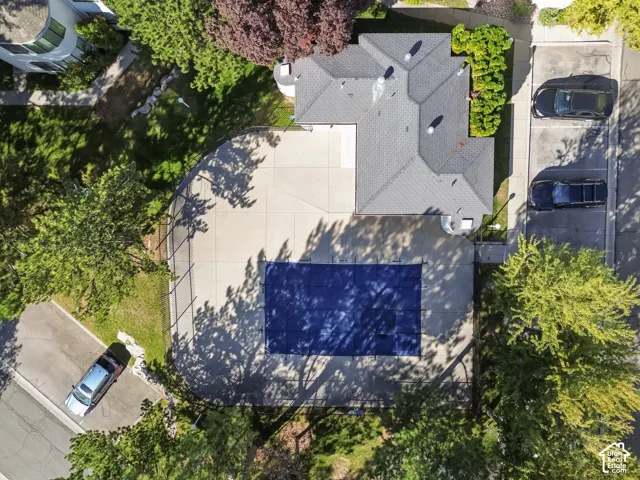 Shingled roofline, paved parking area, and a covered pool