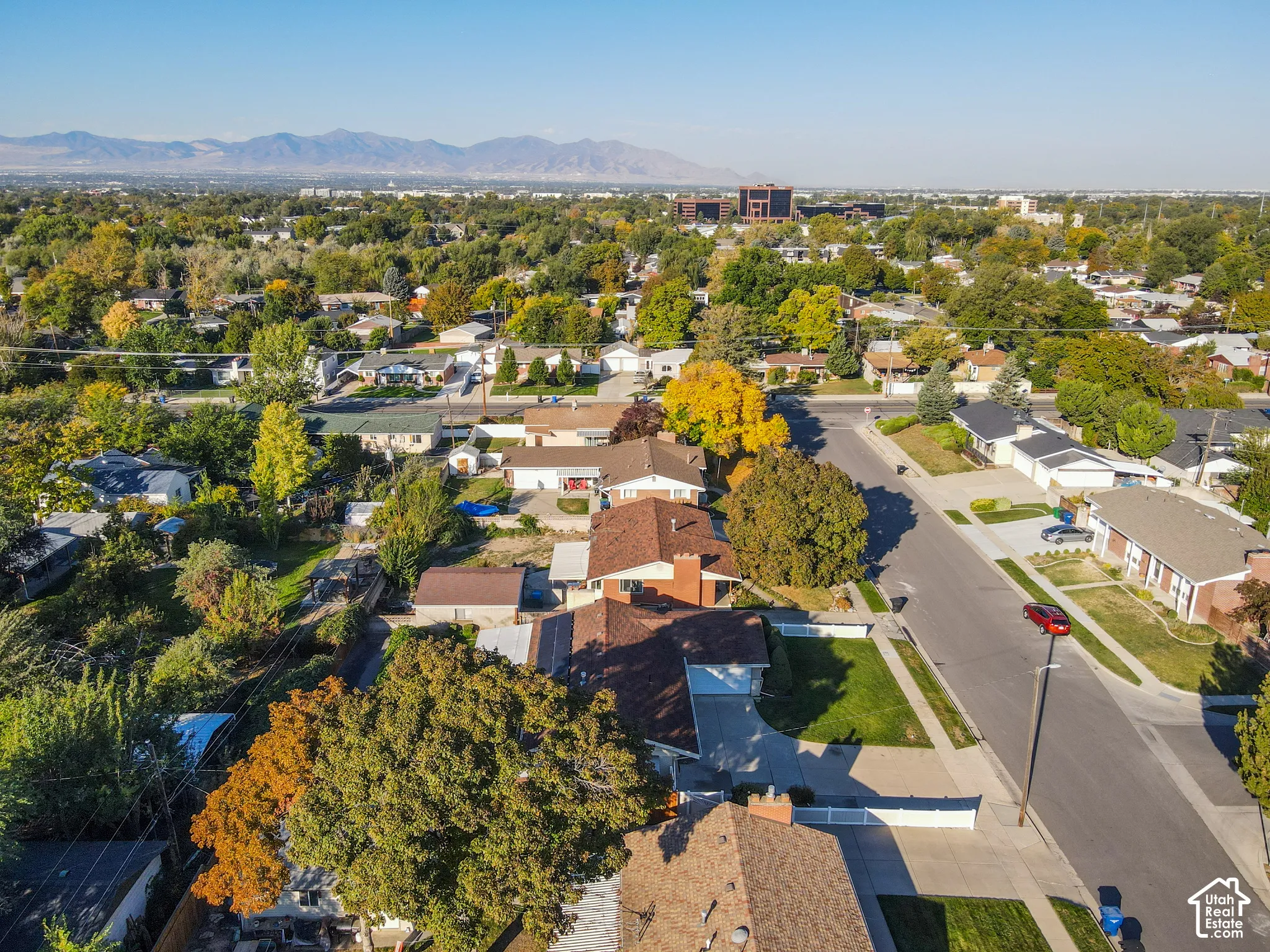 Mountain backdrop, residential street, mature trees, single-story homes, paved sidewalks