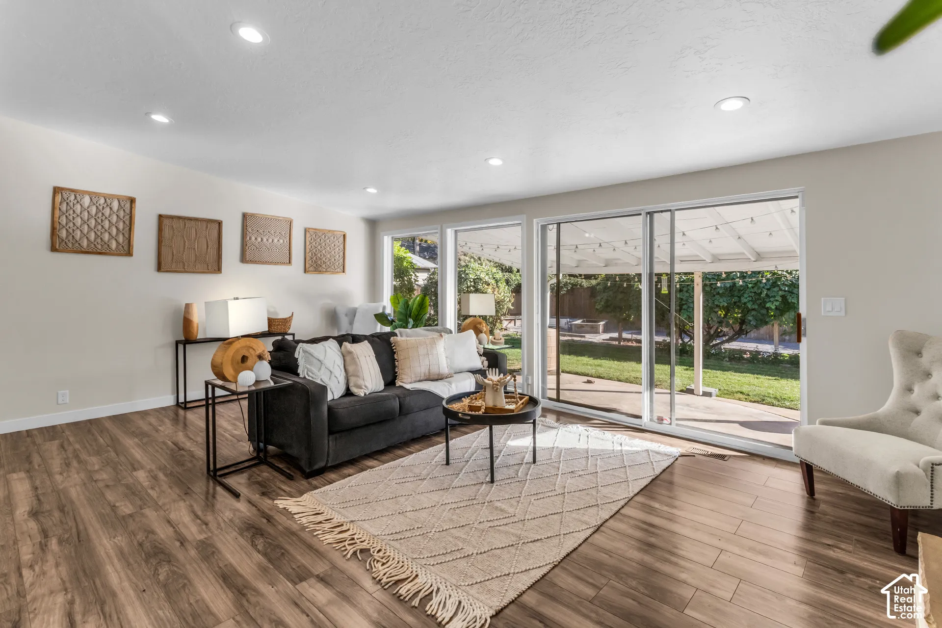 Spacious room featuring wood-finish flooring, recessed lighting, and large sliding glass doors leading to an outdoor patio