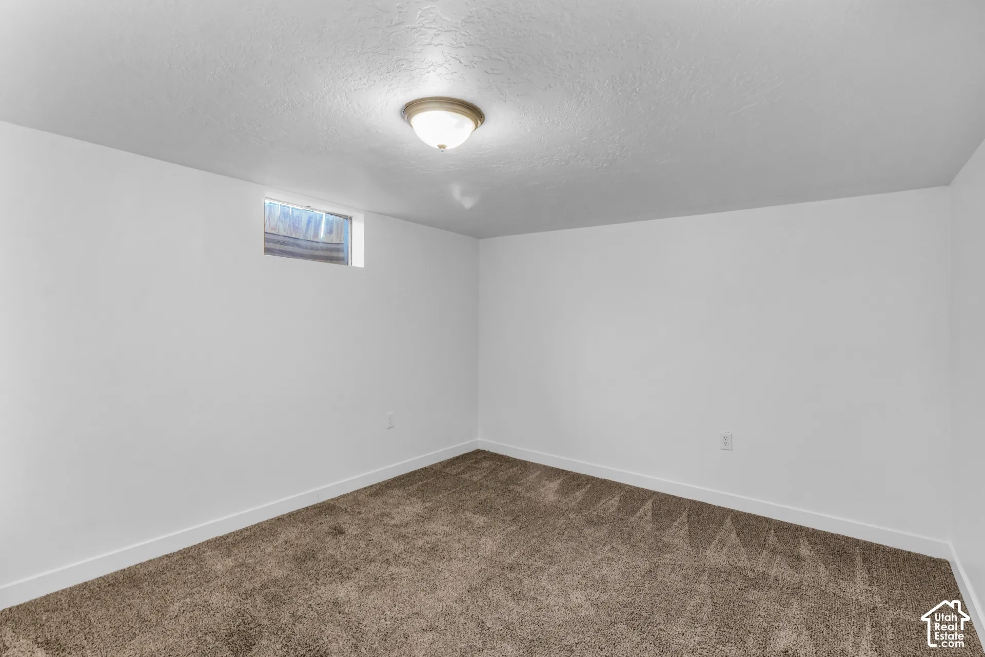 Spacious carpeted den/ office of bonus room featuring neutral wall finishes, recessed ceiling lighting, and a high-set window for natural light