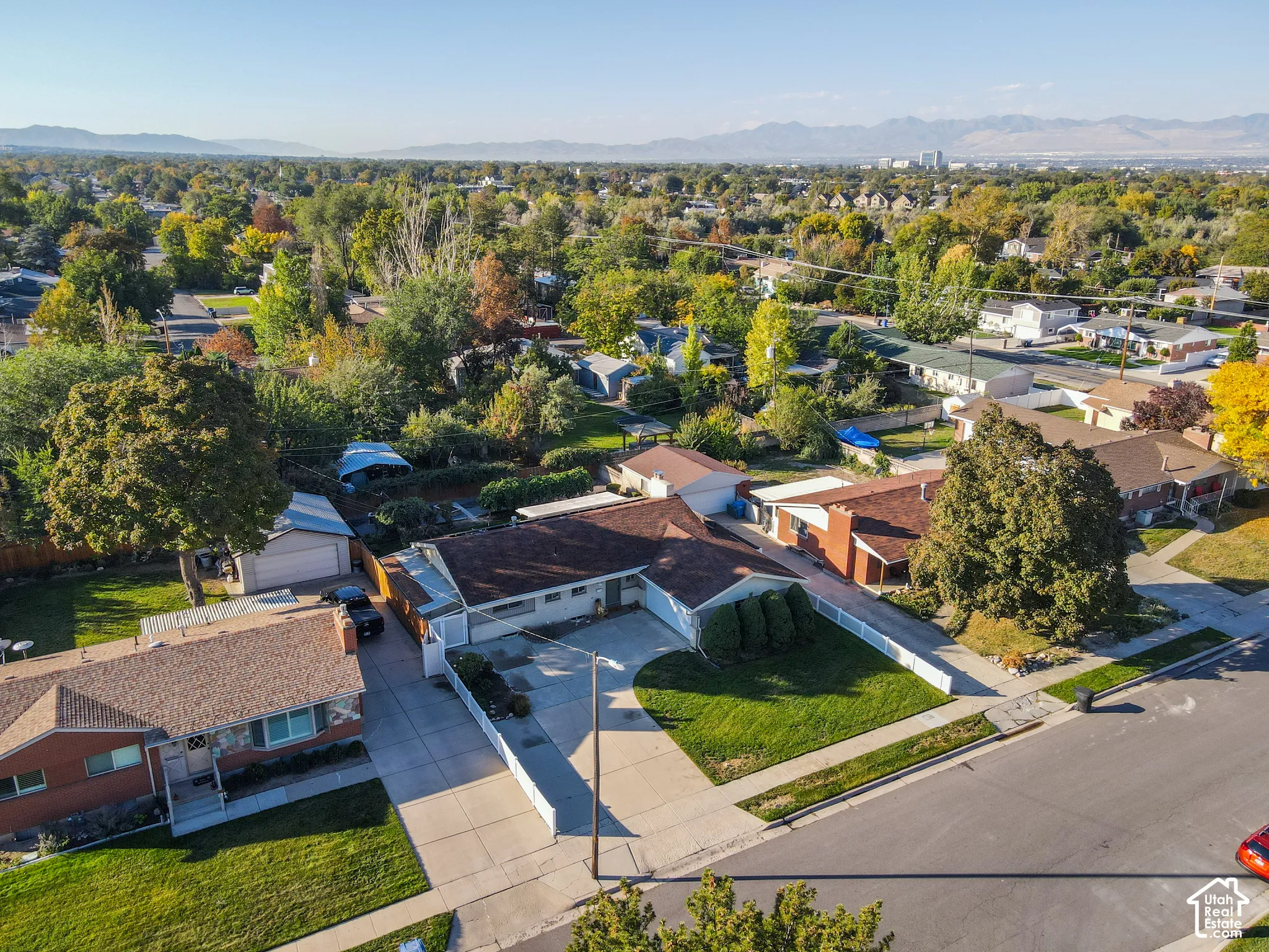 Expansive residential setting with mature trees and mountain backdrop