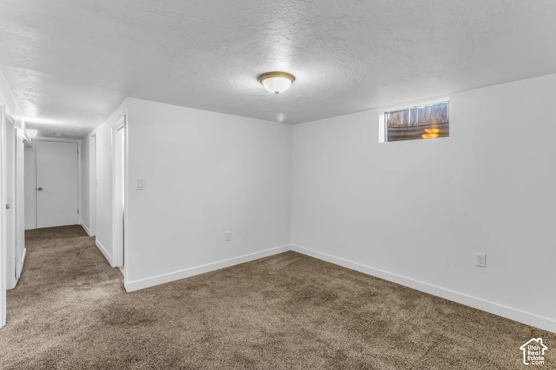 Recessed window, ceiling-mounted light fixture, and neutral carpeting