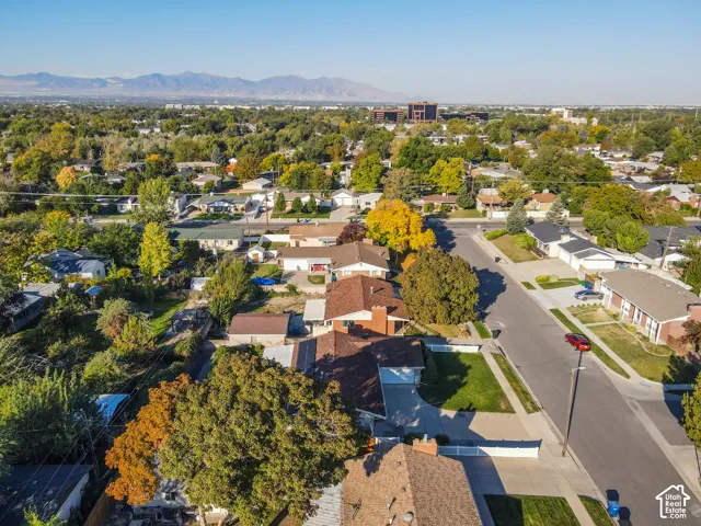 Mountain backdrop, residential street, mature trees, single-story homes, paved sidewalks