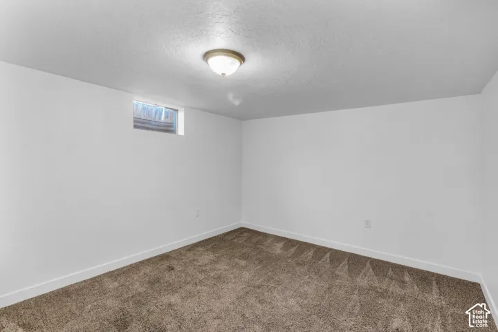 Spacious carpeted den/ office of bonus room featuring neutral wall finishes, recessed ceiling lighting, and a high-set window for natural light