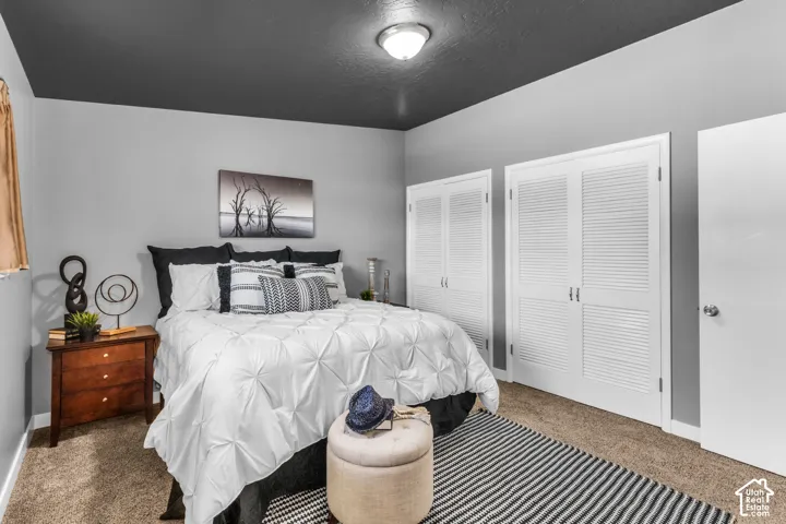 Bright bedroom retreat featuring a black accent ceiling, and double closets.