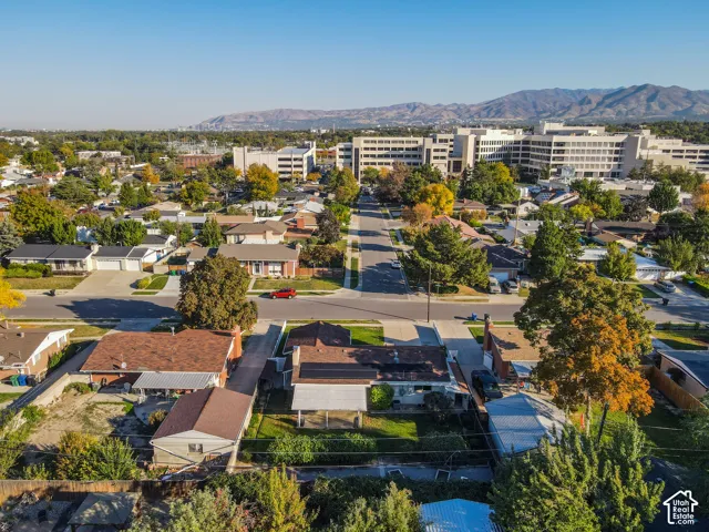 Residential neighborhood with tree-lined streets and distant mountain range backdrop
