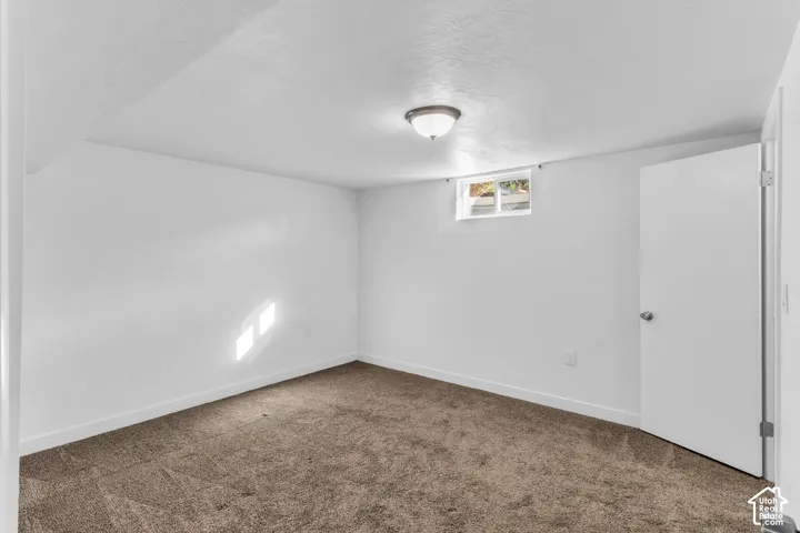 Spacious bedroom featuring neutral wall finishes, carpeted flooring, and abundant natural light from large windows