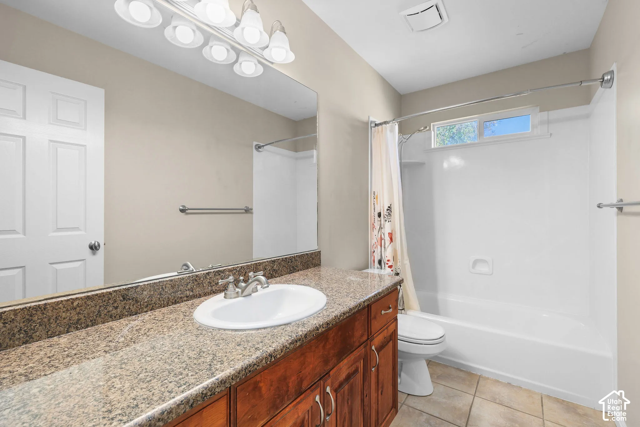 Bathroom with a vanity featuring a granite-finish countertop, undermount sink, and wood-finish cabinetry