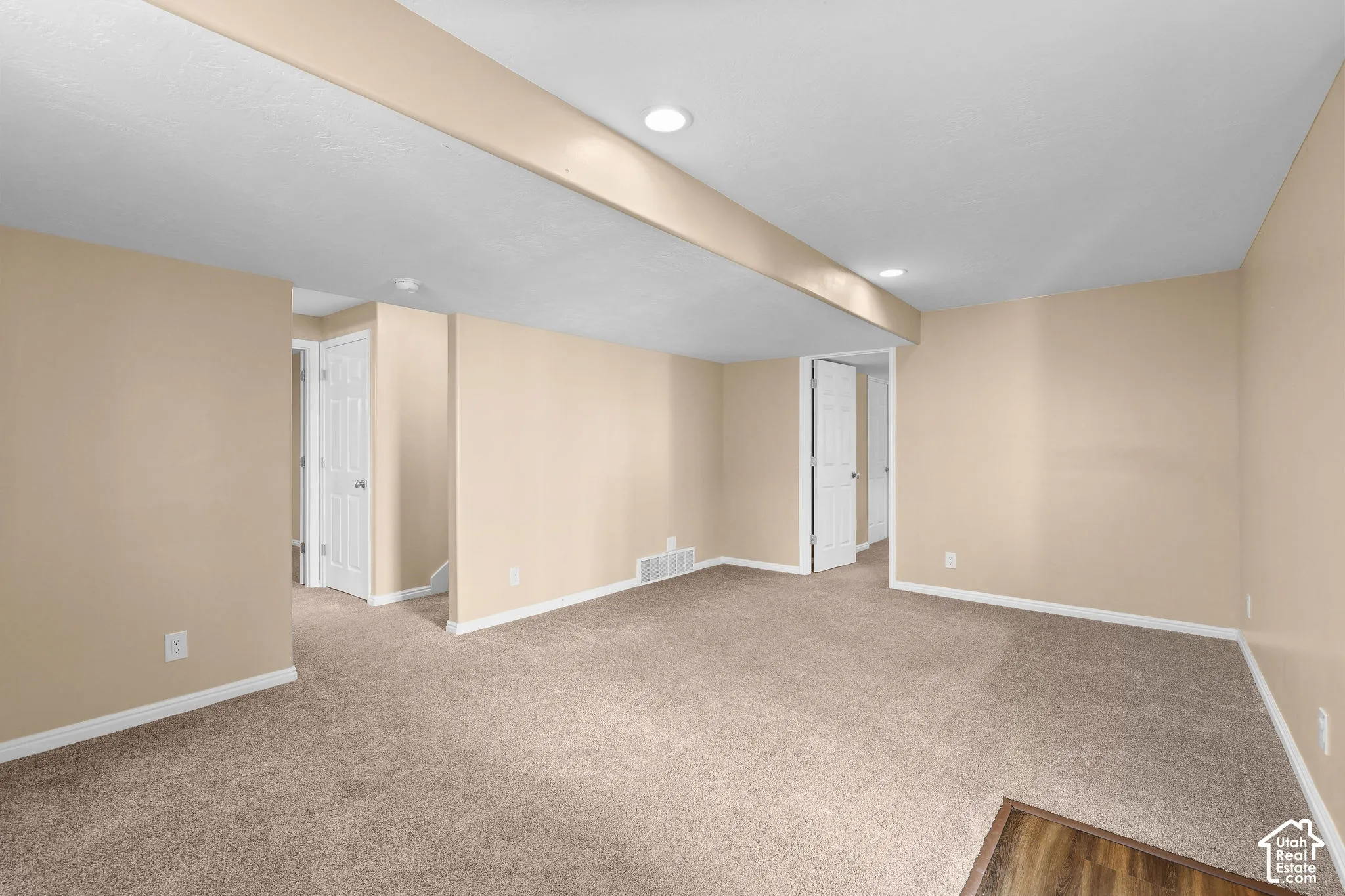 Spacious room featuring neutral paint, recessed lighting, and carpet flooring