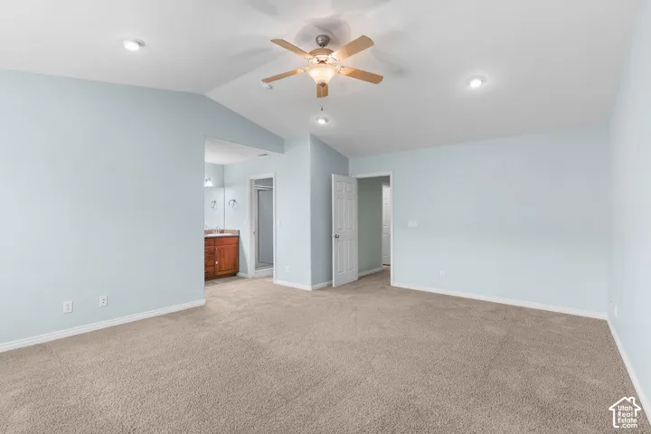 Recessed ceiling lights, ceiling fan with light fixture, carpeted flooring, wood-finish vanity with countertop, and a glass-enclosed shower