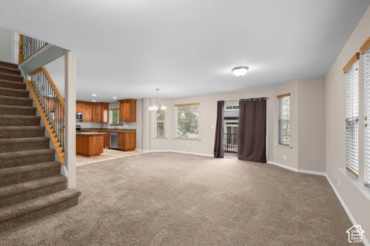 Open concept living space with carpeted flooring