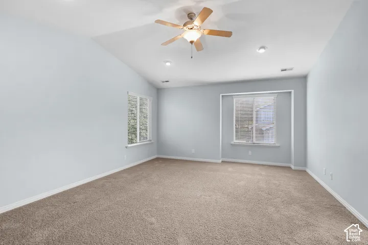 Carpeted flooring, vaulted ceiling, dual windows with blinds, recessed lighting, and a ceiling fan