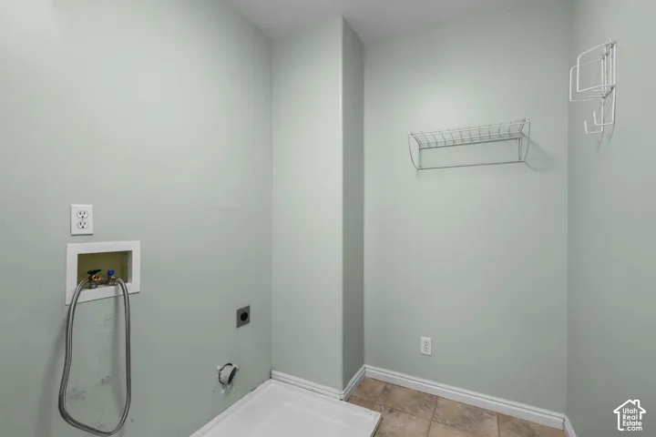 Utility space with tiled flooring and light-colored walls