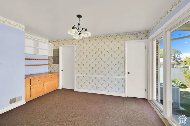 Built-in cabinetry with shelving, recessed lighting, and a chandelier fixture