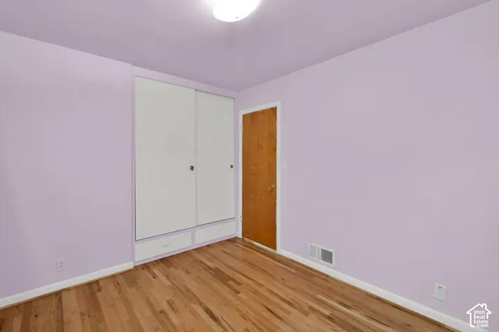 Hardwood flooring, built-in closet with sliding doors, additional built-in drawers, flush mount ceiling light