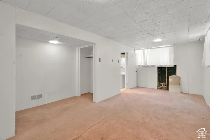 Recessed lighting, drop ceiling, wall-to-wall carpeting, built-in closet, and an interior doorway