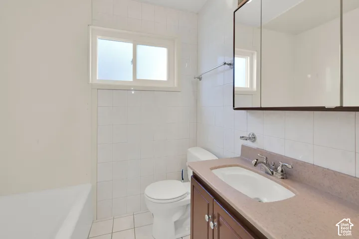 Vanity with an integrated sink and chrome faucet, flanked by a wall-mounted medicine cabinet and a toilet