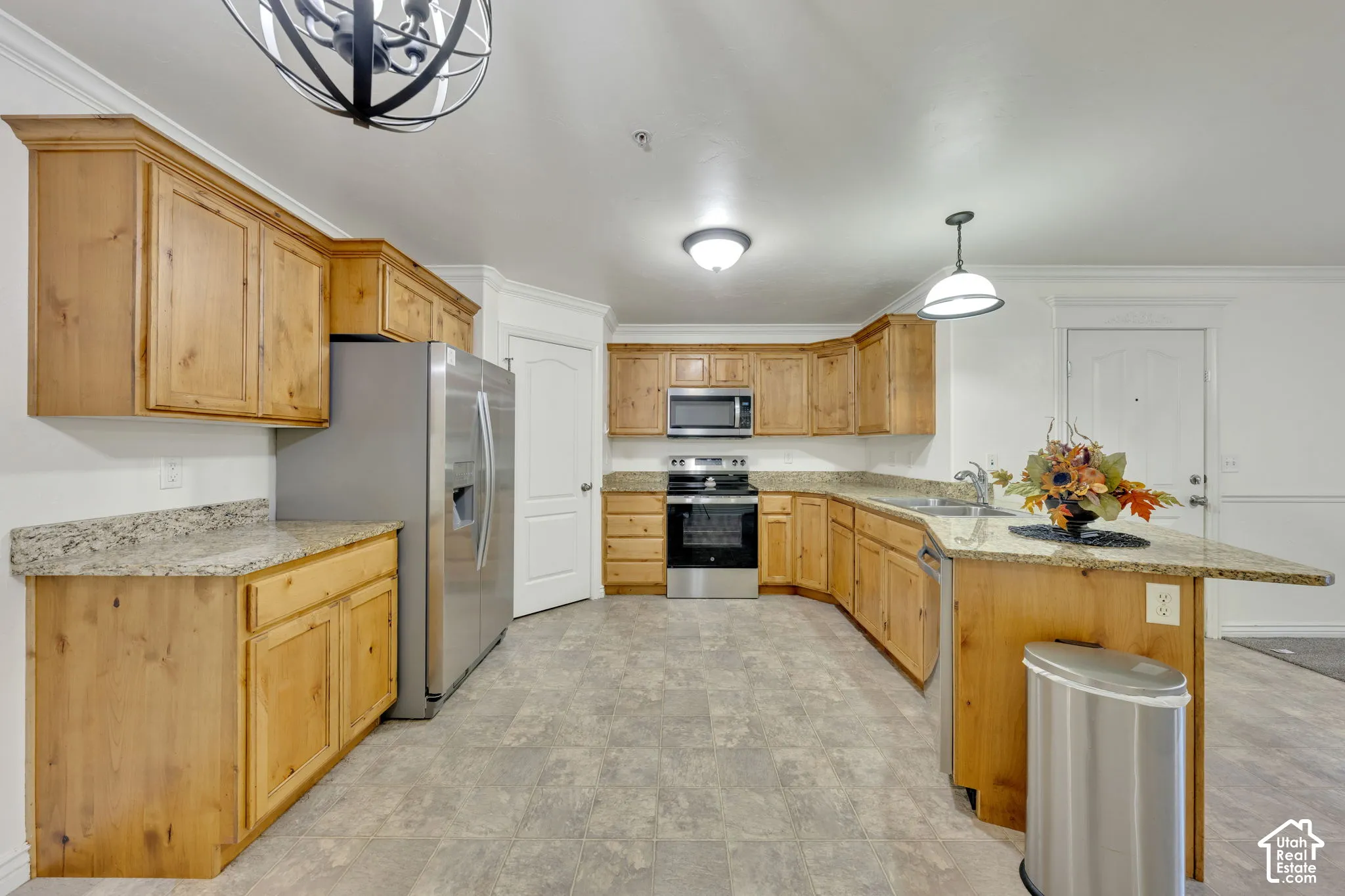 Kitchen featuring wood cabinetry, granite-style countertops, stainless steel appliances, and a built-in dishwasher