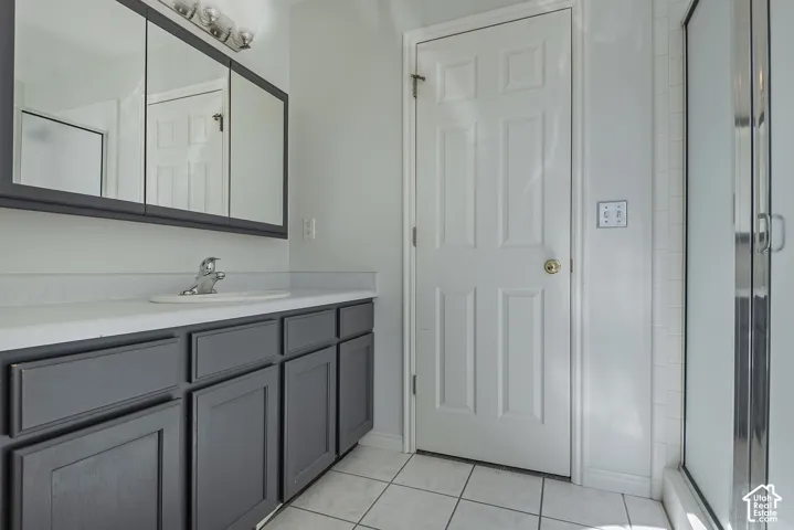 Bathroom vanity with gray cabinetry, white countertop, and integrated sink