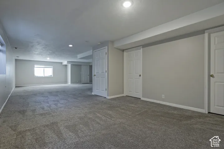 Spacious room featuring neutral carpeting and light gray walls