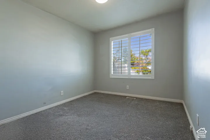 Recessed lighting, painted walls, carpet flooring, a window, and window shutters