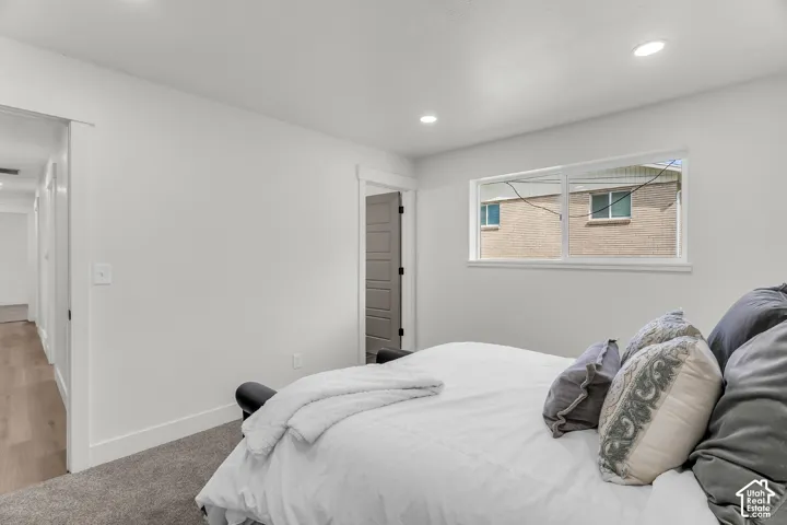 Recessed lighting, white trim, plank flooring, and a carpeted floor