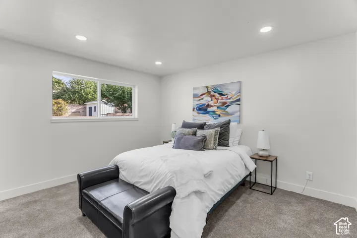 Recessed lighting, wall-to-wall carpeting, and a window with a white frame