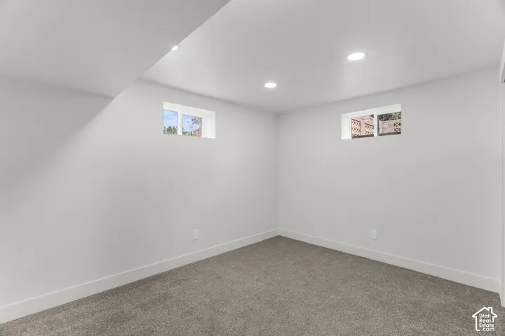 Recessed ceiling lighting, two windows, wall-to-wall carpeting, white wall finishes, and white trim