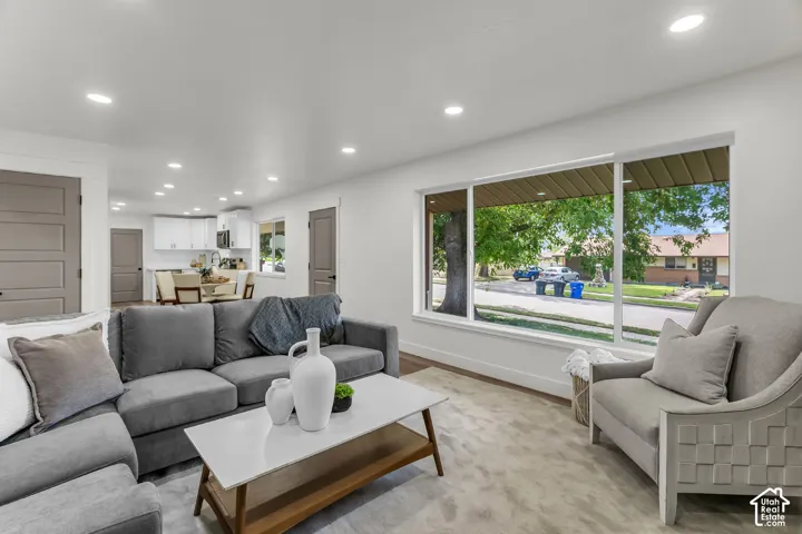 Recessed lighting, wood-finish flooring, white walls, large picture window, and paneled interior doors
