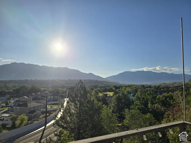 Expansive mountain backdrop with a wide valley and distant residential structures
