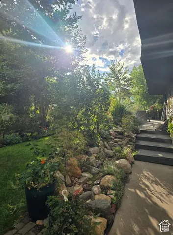 Mature landscaping with lush greenery and established trees creates a serene outdoor setting
