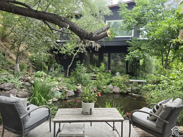 Expansive exterior featuring a koi pond, mature landscaping, and multi-pane windows