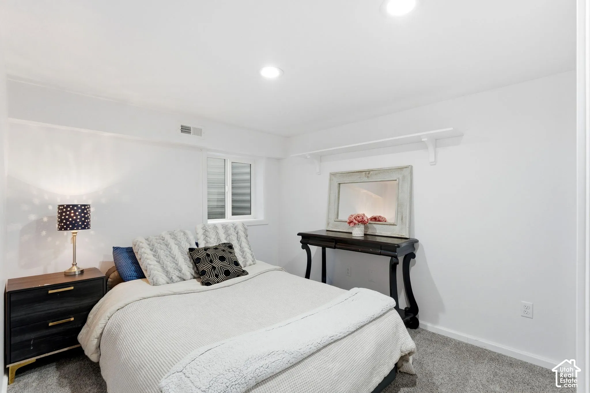 Recessed lighting, wall-to-wall carpeting, and a built-in wall shelf