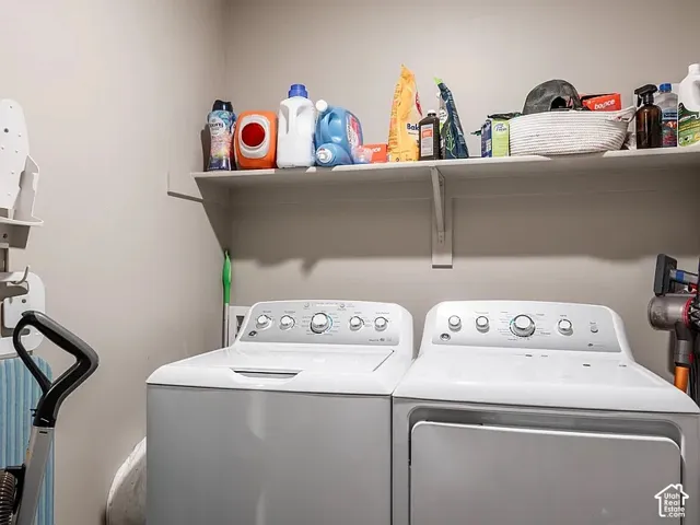 Laundry area featuring a top-load washer, a front-load dryer, and a wall-mounted storage shelf