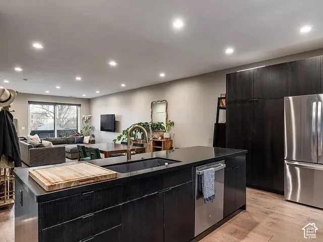 Modern kitchen featuring dark cabinetry, stainless steel appliances, and a built-in dishwasher