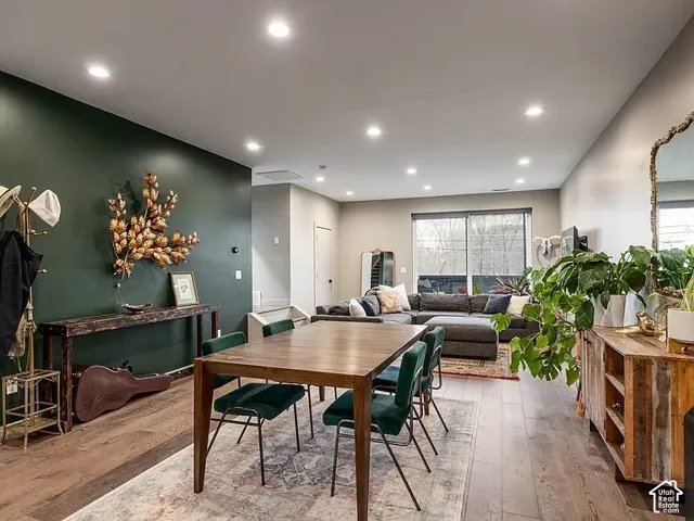 Recessed ceiling lighting, wood-finish flooring, a wall-mounted thermostat, and floor-to-ceiling windows