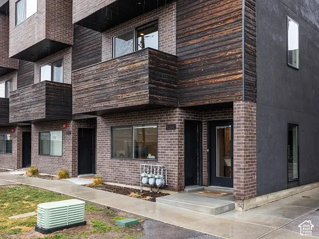 Brick exterior with dark wood-finish siding accents and a concrete walkway