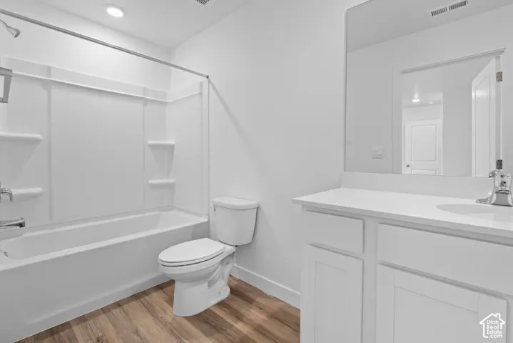 White panel cabinetry with a solid surface countertop, an integrated sink, and a large mirror