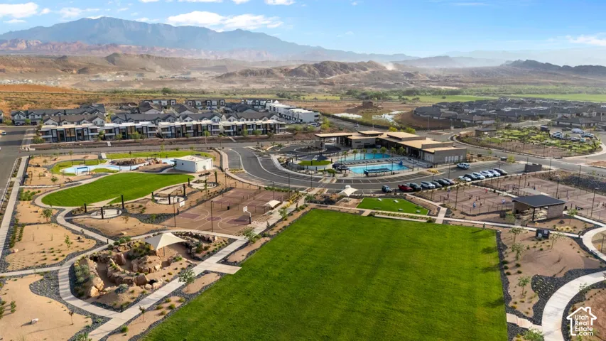 Expansive community grounds featuring a central green space, multiple sports courts, and a large swimming pool area