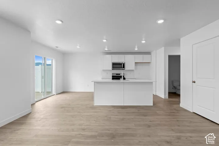 Open-concept living area featuring wood-finish flooring and recessed lighting
