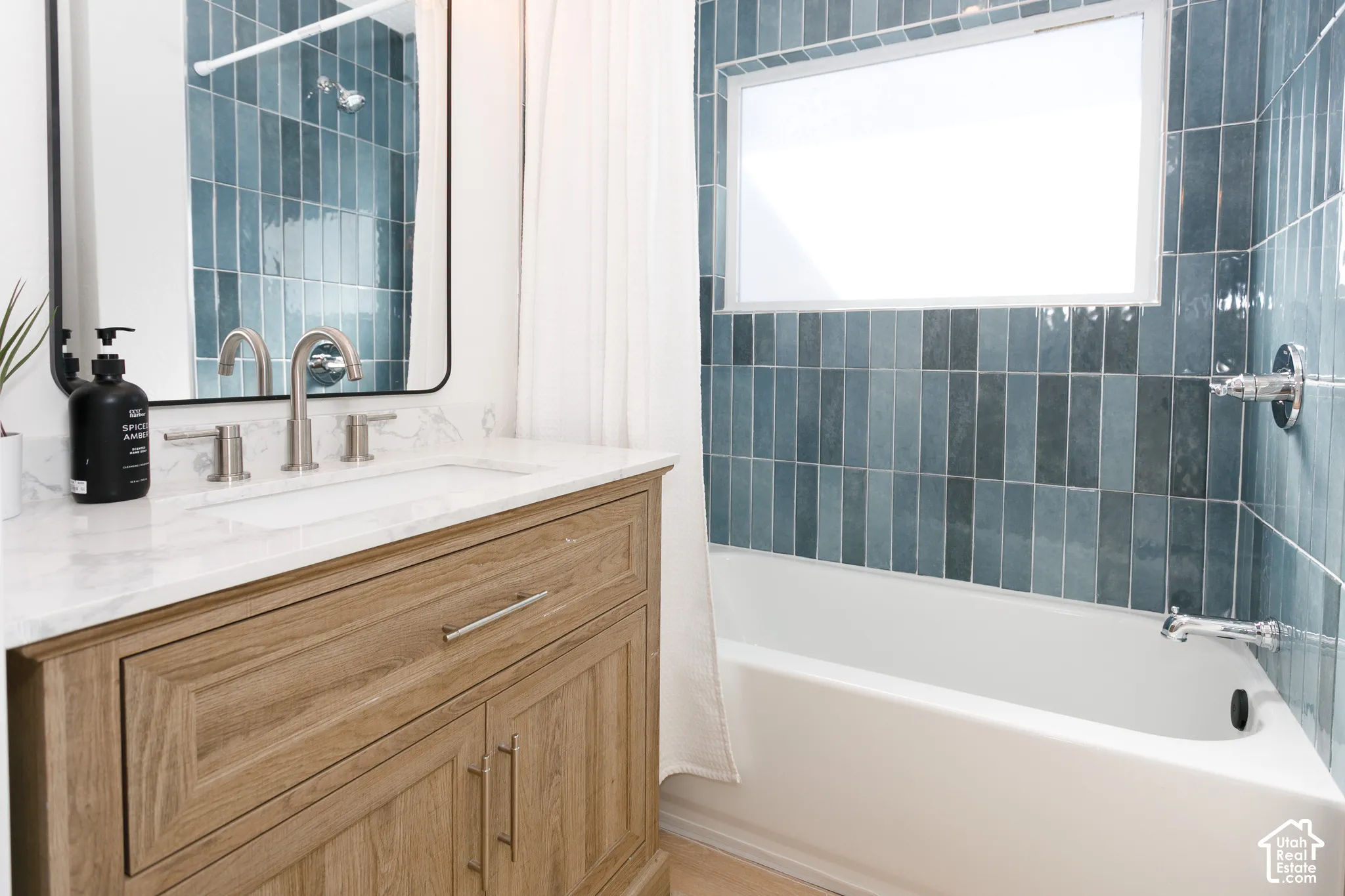 Wood-finish vanity with a white marble countertop, undermount sink, and brushed nickel fixtures