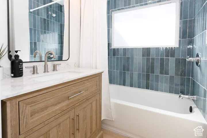 Wood-finish vanity with a white marble countertop, undermount sink, and brushed nickel fixtures