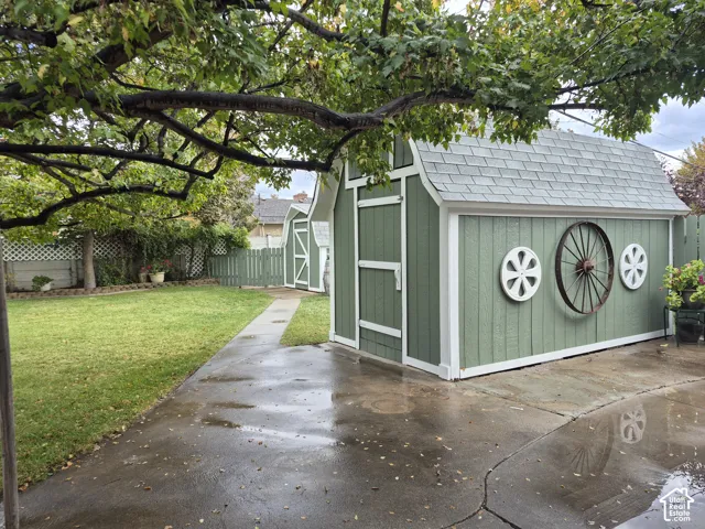 Two detached storage sheds with barn-style doors and shingle roofs