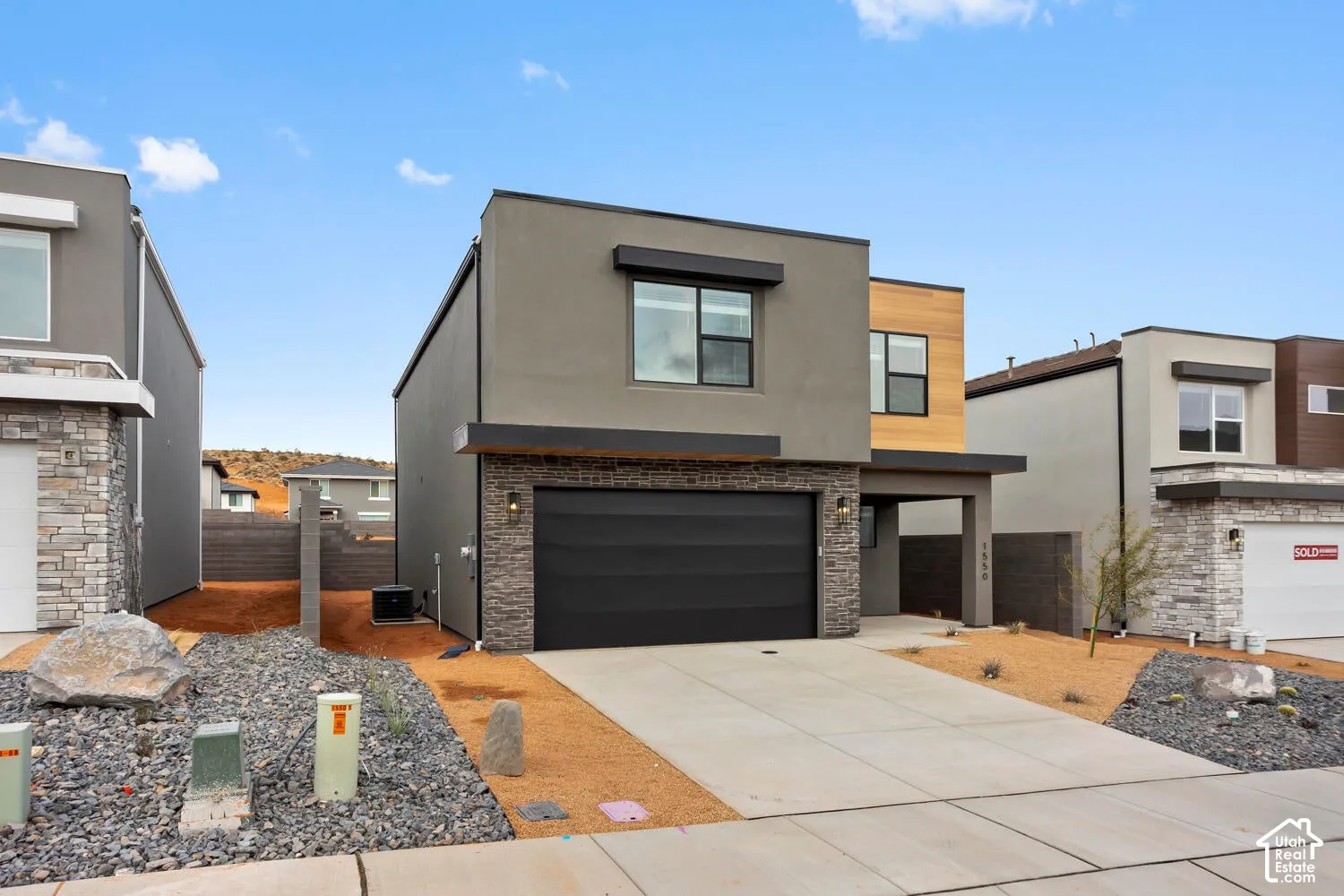 Modern exterior with horizontal wood-look siding, stucco finish, and stone veneer accents