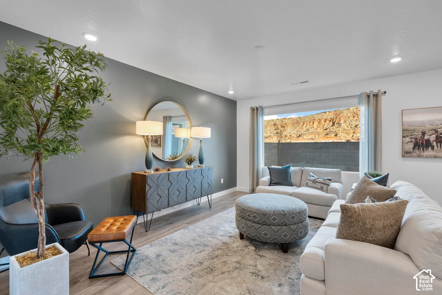 Recessed ceiling lighting, wood-finish flooring, accent wall, built-in wall mirror, and large window with exterior scenery