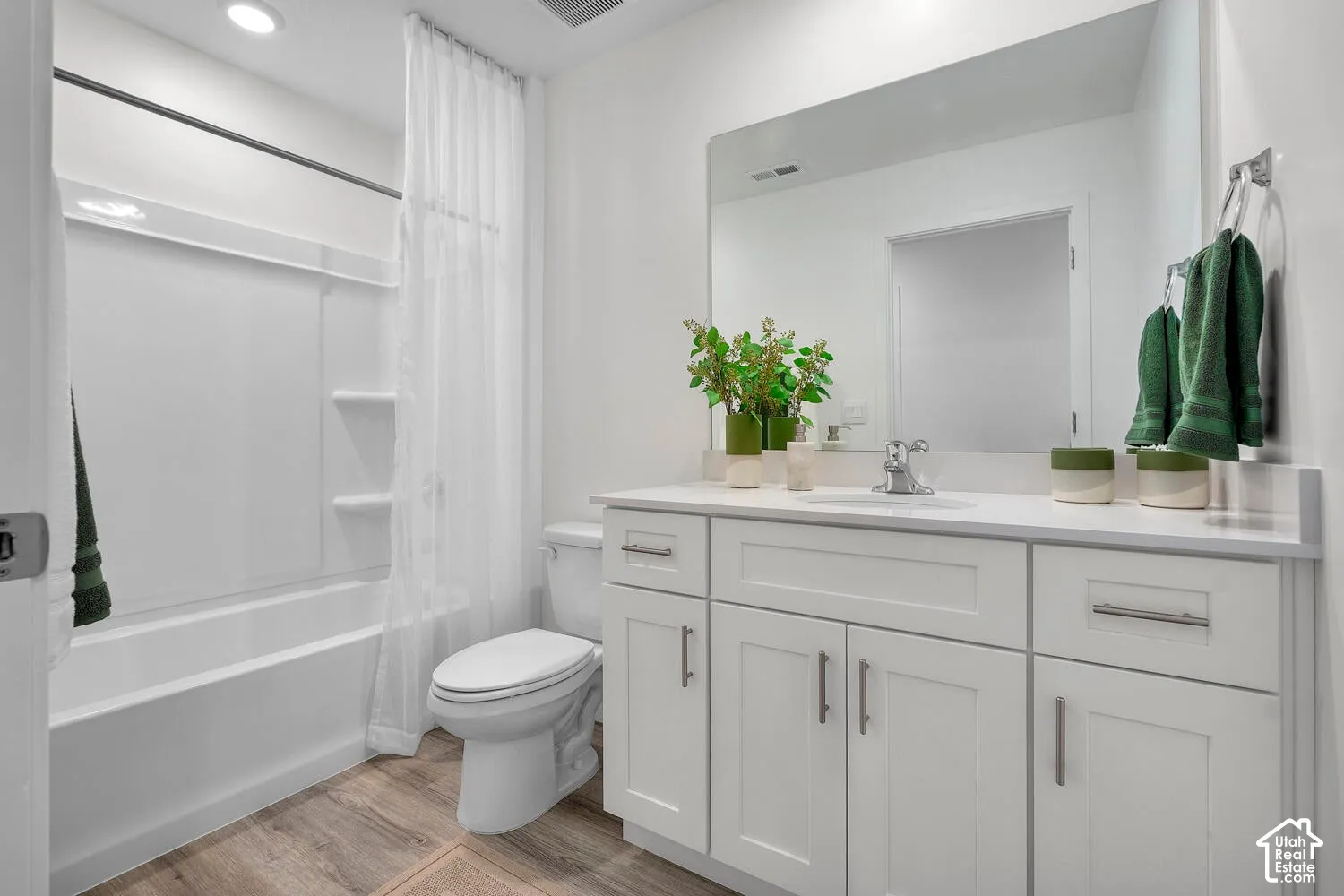 White shaker cabinetry with brushed nickel pulls, a white countertop, and a large wall-mounted mirror