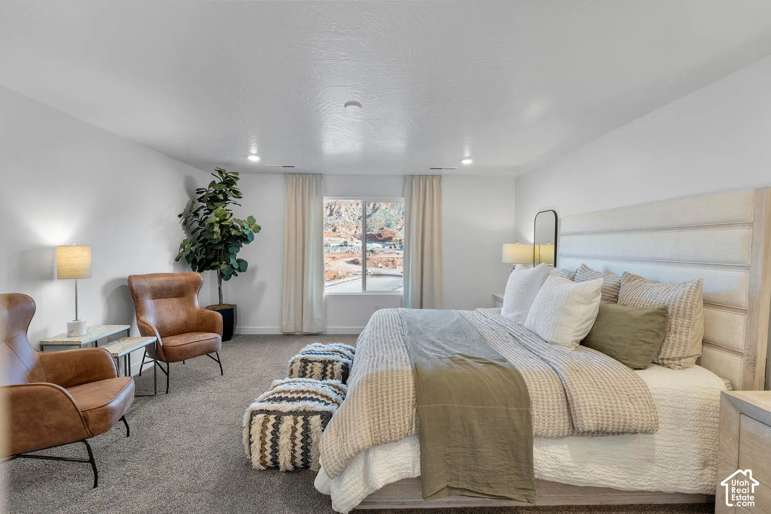 Carpeted flooring, recessed lighting, and a single window with vertical blinds