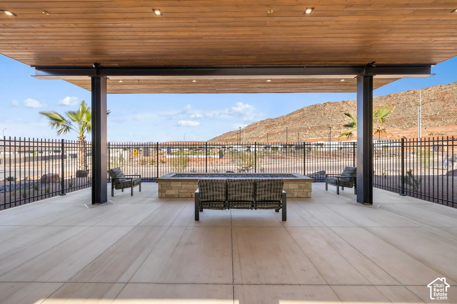 Covered patio featuring a wood-finish ceiling, recessed lighting, and a stone-clad fire pit